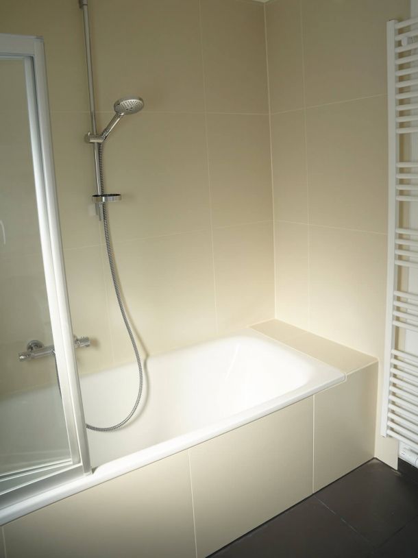 Fliesenarbeiten im Badezimmer mit neu gefliester Badewanne.