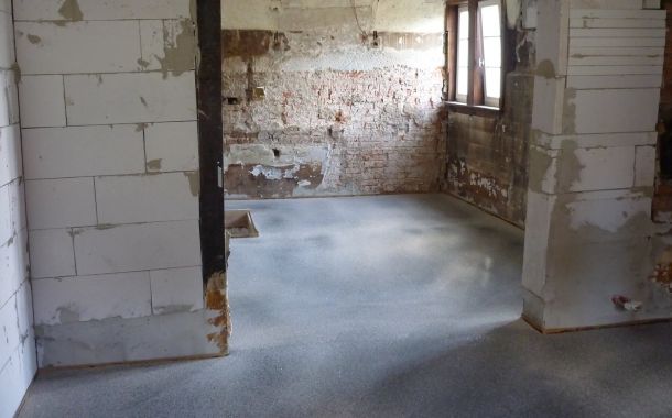 Estricharbeiten zur Nivellierung der unebenen Bodenfläche.