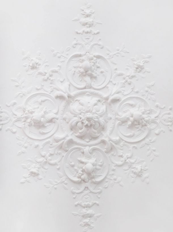 Feine Stuckarbeit: weißer Stuckdekor mit aufwendigen Mustern.