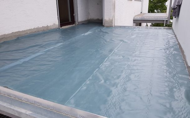 Terrassansanierung: Terrasse mit blauer Schutzfolie abgedeckt während Abdichtungsarbeiten