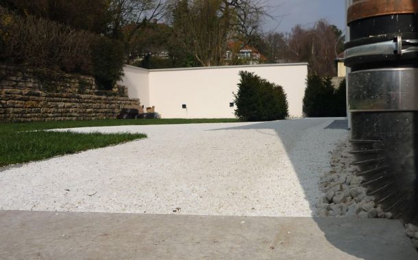 Terrasse mit eleganter Umrandung zu Haus und Rasen.