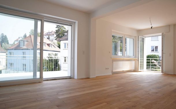 Frisch renovierter Wohnraum mit neuem Parkettboden und glatter weißer Wandgestaltung nach Altbausanierung.