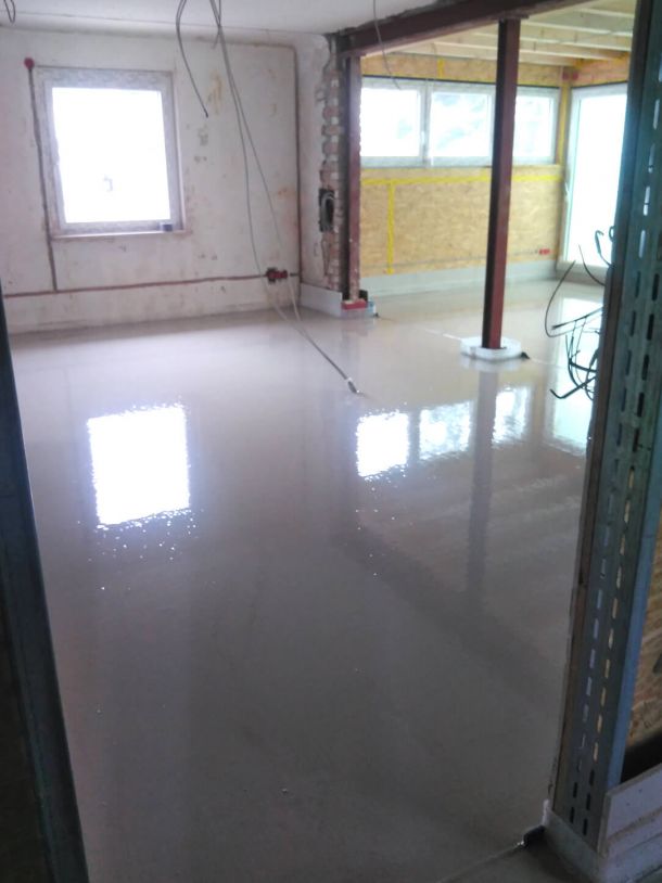 Frisch verlegter glänzender Estrichboden in einem sanierten Gebäude.